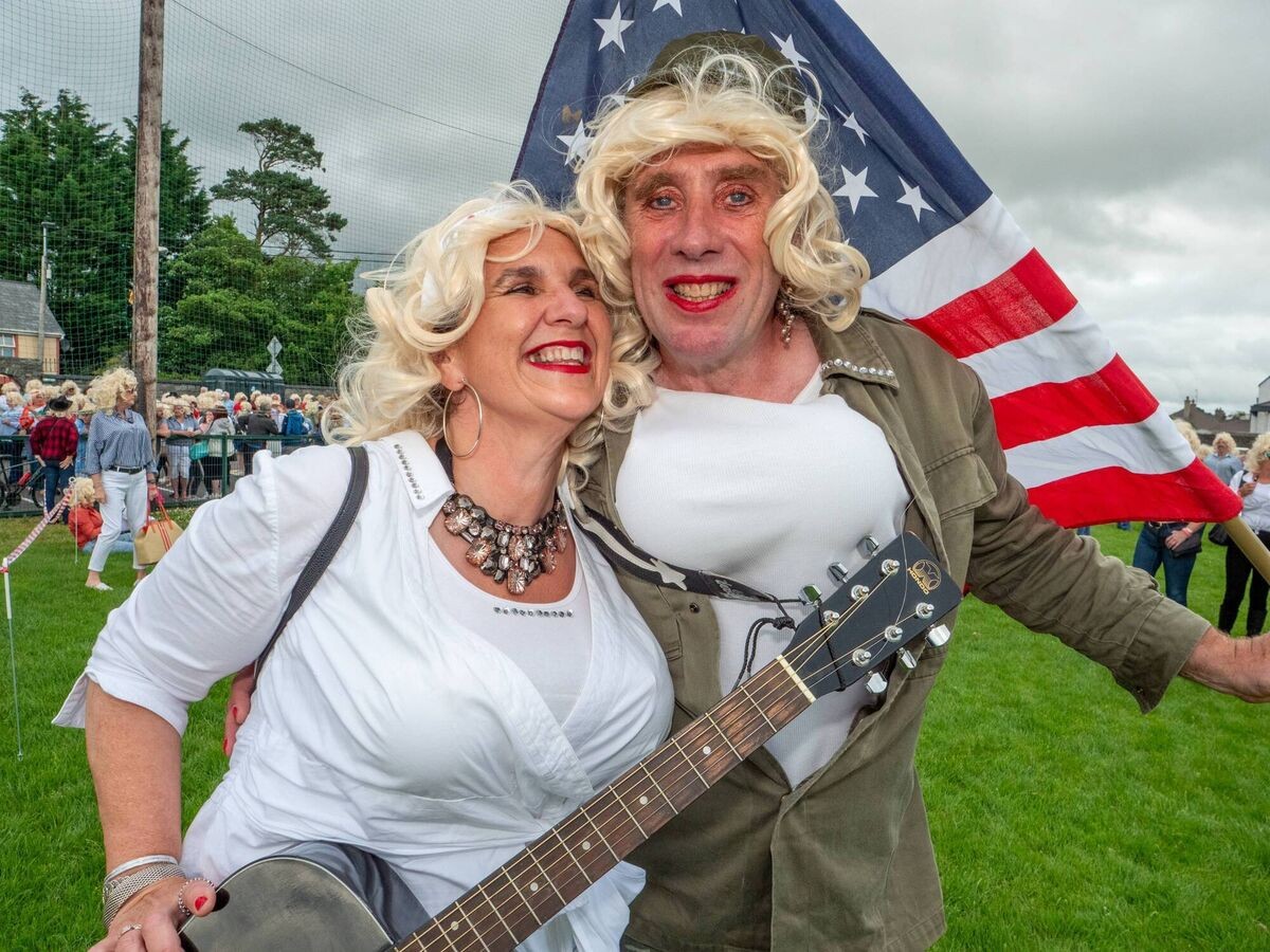 Two attendees in wigs with a guitar and an American flag